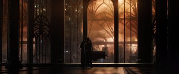Movie still from “Jupiter Ascending” (2015), directed by Lilly Wachowski – Two people standing in front of a large window; Extreme Wide shot, Over the shoulder angle