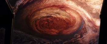 Movie still from “Jupiter Ascending” (2015), directed by Lilly Wachowski – View of a red and brown nebula; Extreme Wide shot, Overhead angle