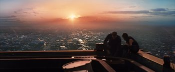 Movie still from “Jupiter Ascending” (2015), directed by Lilly Wachowski – Two men are looking out over a city at sunset; Extreme Wide shot, Low angle