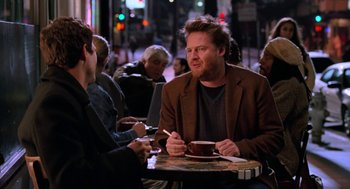 Movie still from “Just Like Heaven” (2005), directed by Mark Waters – A man sitting at a table with a cup of coffee; Medium shot, Over the shoulder angle