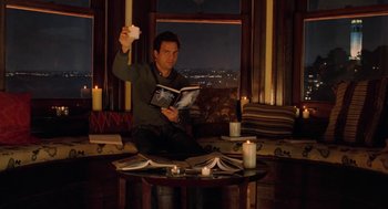 Movie still from “Just Like Heaven” (2005), directed by Mark Waters – A man sitting in a living room holding a book; Medium shot, High angle