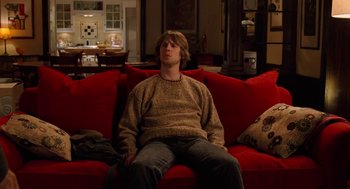 Movie still from “Just Like Heaven” (2005), directed by Mark Waters – A man sitting on a red couch in a living room; Wide shot, High angle