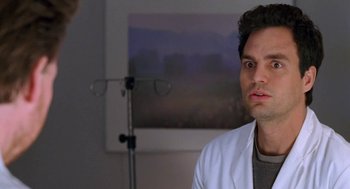 Movie still from “Just Like Heaven” (2005), directed by Mark Waters – A man wearing a white lab coat in front of a picture; Close Up shot, Over the shoulder angle