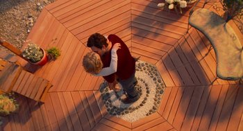 A man and a woman kissing on the ground