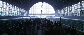 Movie still from “K-19: The Widowmaker” (2002), directed by Kathryn Bigelow – A group of people standing in front of a train station; Extreme Wide shot, High angle