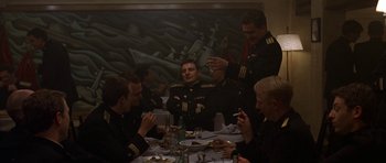 Movie still from “K-19: The Widowmaker” (2002), directed by Kathryn Bigelow – A group of men sitting at a table eating food; Wide shot, Low angle