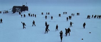 Movie still from “K-19: The Widowmaker” (2002), directed by Kathryn Bigelow – A group of people standing on top of a snow covered field; Extreme Wide shot, High angle