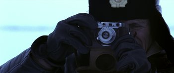 Movie still from “K-19: The Widowmaker” (2002), directed by Kathryn Bigelow – A person holding an old fashioned camera in their hands; Extreme Close Up shot, Overhead angle