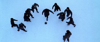 Movie still from “K-19: The Widowmaker” (2002), directed by Kathryn Bigelow – A group of men playing a game of soccer on a snowy day; Wide shot, Overhead angle