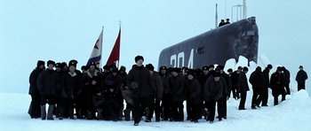 Movie still from “K-19: The Widowmaker” (2002), directed by Kathryn Bigelow – A group of people standing in front of a boat in the snow; Wide shot, Low angle