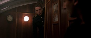 Movie still from “K-19: The Widowmaker” (2002), directed by Kathryn Bigelow – A man in a uniform looking into a mirror; Medium shot, Over the shoulder angle