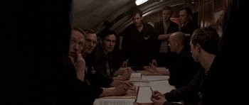 Movie still from “K-19: The Widowmaker” (2002), directed by Kathryn Bigelow – A group of men sitting at a table with papers; Medium shot, High angle