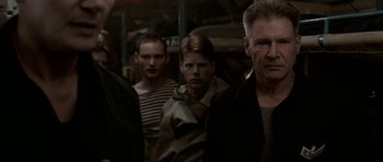 Movie still from “K-19: The Widowmaker” (2002), directed by Kathryn Bigelow – A group of men standing next to each other in a room; Medium shot, Over the shoulder angle