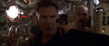 Movie still from “K-19: The Widowmaker” (2002), directed by Kathryn Bigelow – A person holding a gun; Close Up shot, Over the shoulder angle