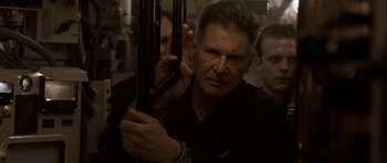 Movie still from “K-19: The Widowmaker” (2002), directed by Kathryn Bigelow – A person holding a gun; Close Up shot, Over the shoulder angle