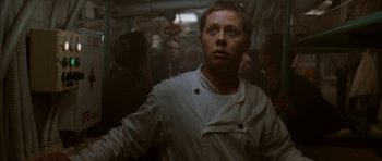 Movie still from “K-19: The Widowmaker” (2002), directed by Kathryn Bigelow – A man standing in the middle of a crowded room; Close Up shot, Low angle
