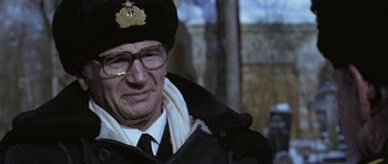 Movie still from “K-19: The Widowmaker” (2002), directed by Kathryn Bigelow – An older man wearing a hat and glasses; Close Up shot, Low angle