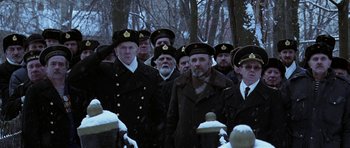 Movie still from “K-19: The Widowmaker” (2002), directed by Kathryn Bigelow – A group of men standing next to a fire hydrant in the snow; Medium shot, Low angle