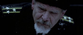 Movie still from “K-19: The Widowmaker” (2002), directed by Kathryn Bigelow – An older man with a beard and a hat; Close Up shot, Over the shoulder angle