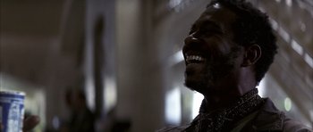 Movie still from “K-PAX” (2001), created by Robert Cochran – A person smiling with his mouth wide open; Close Up shot, Low angle