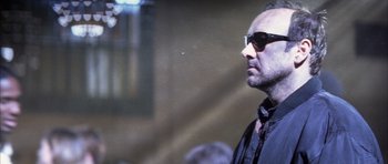 Movie still from “K-PAX” (2001), created by Robert Cochran – A person wearing sunglasses; Close Up shot, Low angle