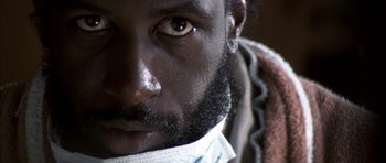 Movie still from “K-PAX” (2001), created by Robert Cochran – A man's face wearing a face mask; Extreme Close Up shot, Low angle