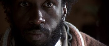 Movie still from “K-PAX” (2001), created by Robert Cochran – A man's face with a beard; Extreme Close Up shot, Low angle