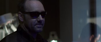 Movie still from “K-PAX” (2001), created by Robert Cochran – A person wearing sunglasses; Close Up shot, Over the shoulder angle