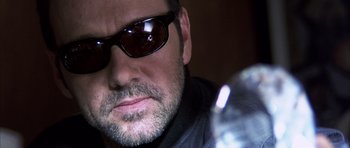 Movie still from “K-PAX” (2001), created by Robert Cochran – A person wearing sunglasses; Close Up shot, Low angle