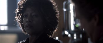 Movie still from “K-PAX” (2001), created by Robert Cochran – A woman's face in a dark room; Close Up shot, Over the shoulder angle