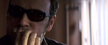 Movie still from “K-PAX” (2001), created by Robert Cochran – A person wearing sunglasses; Close Up shot, Low angle