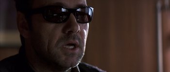 Movie still from “K-PAX” (2001), created by Robert Cochran – A person wearing sunglasses; Close Up shot, Over the shoulder angle