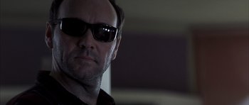 Movie still from “K-PAX” (2001), created by Robert Cochran – A person wearing sunglasses; Close Up shot, Over the shoulder angle