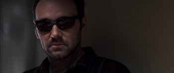 Movie still from “K-PAX” (2001), created by Robert Cochran – A person wearing sunglasses; Close Up shot, Low angle