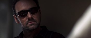 Movie still from “K-PAX” (2001), created by Robert Cochran – A person wearing sunglasses; Close Up shot, Low angle