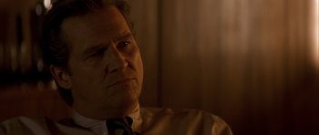 Movie still from “K-PAX” (2001), created by Robert Cochran – A person wearing a suit and tie; Close Up shot, Low angle