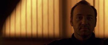 Movie still from “K-PAX” (2001), created by Robert Cochran – A person sitting in front of a window; Close Up shot, Low angle