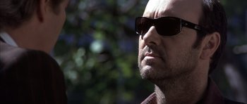 Movie still from “K-PAX” (2001), created by Robert Cochran – A person wearing sunglasses; Close Up shot, Low angle