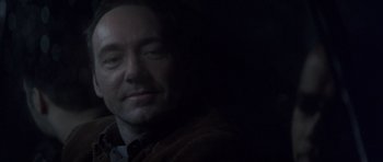 Movie still from “K-PAX” (2001), created by Robert Cochran – A person in a dark room; Close Up shot, High angle