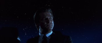 Movie still from “K-PAX” (2001), created by Robert Cochran – A person wearing a suit and tie; Close Up shot, Low angle