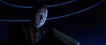 Movie still from “K-PAX” (2001), created by Robert Cochran – A man is looking at a computer screen in the dark; Medium shot, Low angle