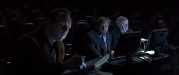 Movie still from “K-PAX” (2001), created by Robert Cochran – A group of people sitting in a theater; Medium shot, Over the shoulder angle