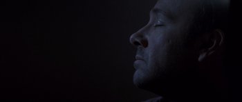 Movie still from “K-PAX” (2001), created by Robert Cochran – A person's face in the dark; Close Up shot, High angle