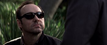 Movie still from “K-PAX” (2001), created by Robert Cochran – A person wearing sunglasses; Close Up shot, Over the shoulder angle