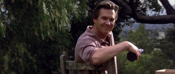 Movie still from “K-PAX” (2001), created by Robert Cochran – A person sitting in a chair near a tree; Close Up shot, Low angle