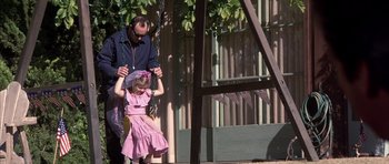 Movie still from “K-PAX” (2001), created by Robert Cochran – A man and a little girl are on a swing; Medium shot, High angle