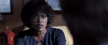 Movie still from “K-PAX” (2001), created by Robert Cochran – A person sitting in a chair; Close Up shot, Over the shoulder angle