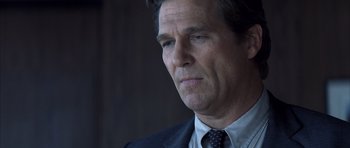 Movie still from “K-PAX” (2001), created by Robert Cochran – A person wearing a suit and tie; Close Up shot, Low angle