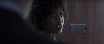 Movie still from “K-PAX” (2001), created by Robert Cochran – A person with short black hair; Close Up shot, Over the shoulder angle