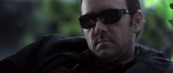 Movie still from “K-PAX” (2001), created by Robert Cochran – A person wearing sunglasses; Close Up shot, Low angle